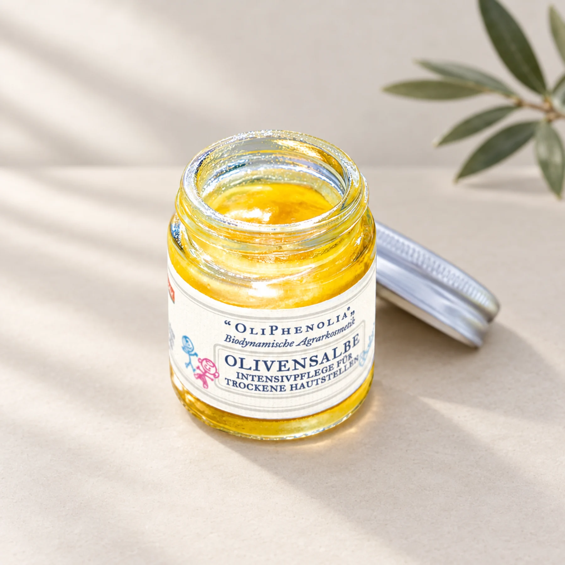 Geöffneter Tiegel der OliPhenolia Olivensalbe mit goldgelber Salbe